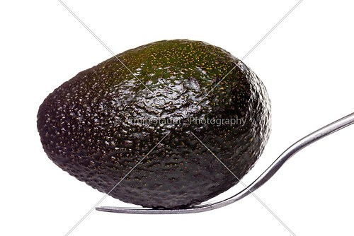 an avocado laying on a for, isolated on white