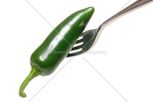 green hot chili on a fork, isolated on white