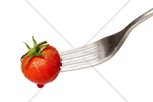 cherry tomato spiked by a fork with a drop of blood, isolated on