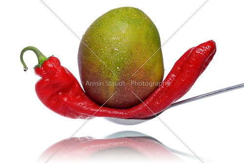 mango fruit squashes a bell peppers on a spoon, isolated on whit