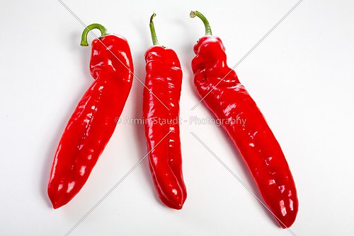 a group of red bell peppers on a white background