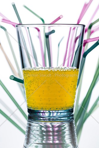 water glass with straws in the background