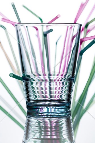 water glass with straws in the background