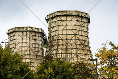 two old cooling towers with some trees in front