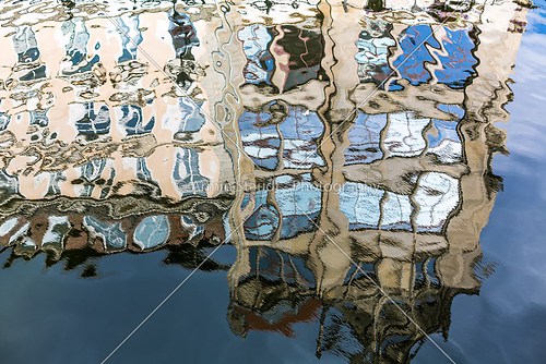 house with blue sky mirroring in a vibrant water surface