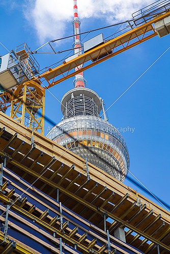 top of the berlin tv tower seen through a construction site