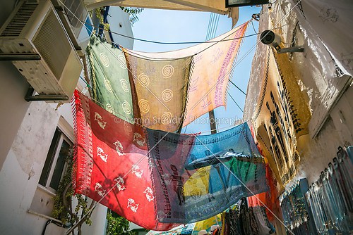 colored foulards hanging between houses in back lit