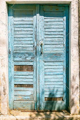 very old blue grungy greek door in summer