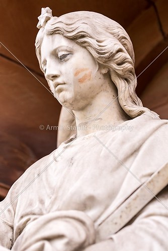 close up of a marble sculpture with lipstick kiss on her cheek