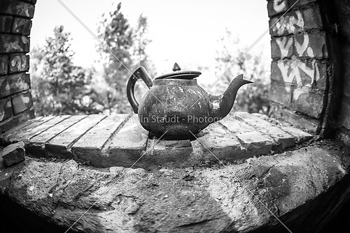 fish eye close up of a very old rusty tea pot
