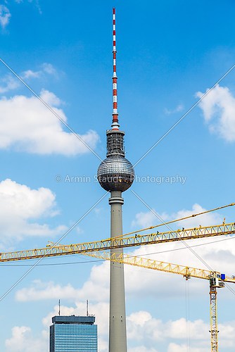 berlin tv tower with two building cranes