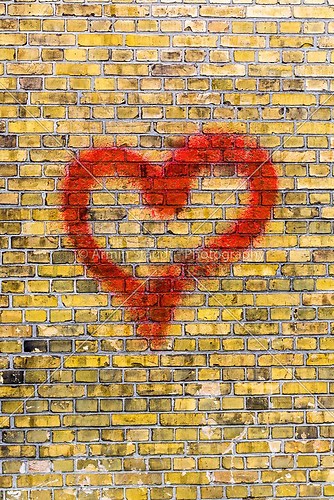heart graffiti on a yellow brick wall background