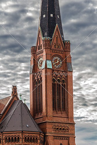 closeup of a red brick steeple with dramatic sky