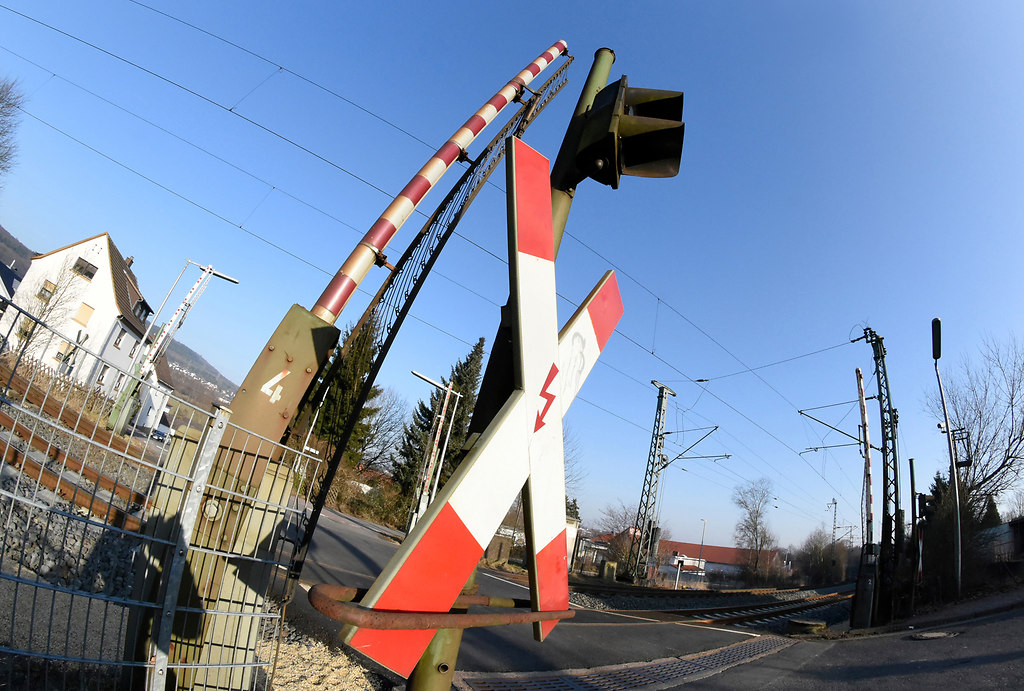 Railroad Crossing (Railroad Crossing) | Railroad crossing low angle view against blue sky open without train | low angle view, railroad, St.Andrew’s Cross, outdoors, no people, multi colored, transportation system, travel, industry, business, technology, street, city, urban, architecture, road, traffic, urban, daylight