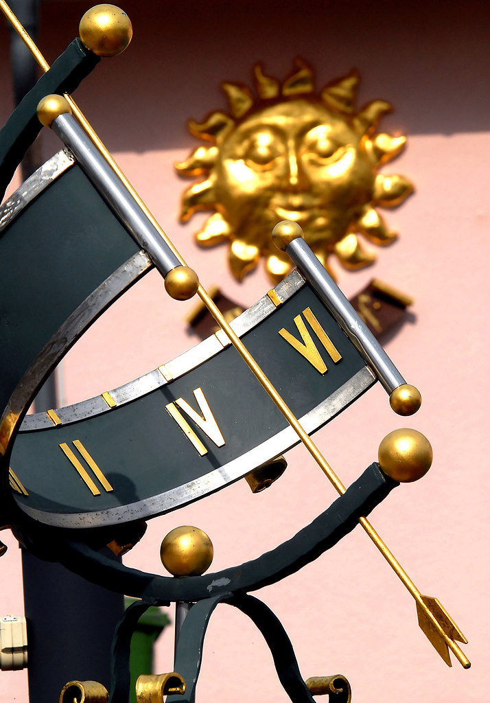 Sundial (Sundial) | Beautuful Sundial standing near by a house with a sun symbol | sundial, close up, sunny, day, golden, sun, time, gold, roman numerals