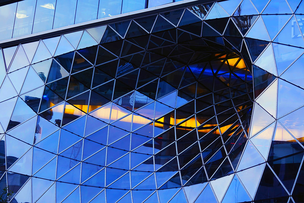Take a gander at a generous glass facade (Take a gander at a generous glass facade) | Glass facade zoomed in | architecture, glass, generous, facade, lights, yellow, triangles, squares, reflections, windows, low angle view, pattern, built structure, building exterior, illuminated, futuristic, close-up, no people, stock image, images, royalty free photo, stock photos, stock photograph, stock photographs, picture, pictures, graphic, graphics