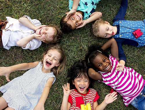 Group of kindergarten kids lying on the grass at park and relax  (Kita5)