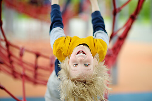 Сute perky preschooler boy having fun on outdoor playground. Sp (Kita2)